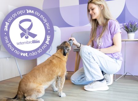 Mulher sorridente, vestindo camiseta lilás, oferece petisco a um cachorro de porte médio em um ambiente interno. Ao lado, um selo circular roxo da campanha Setembro Lilás traz a mensagem “me leva no vet, não só no pet!” e um laço lilás estilizado.